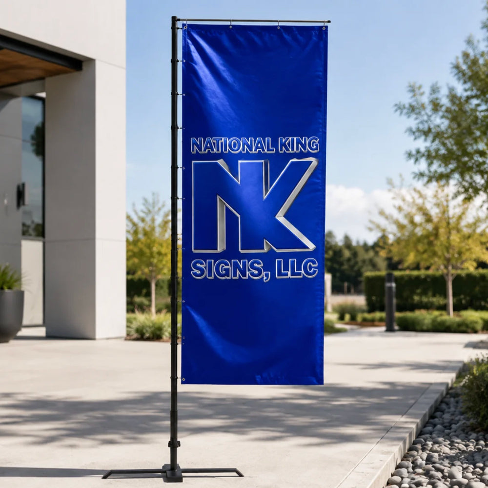 Print Solution Plus branded blue rectangular promotional flag on a black pole with cross base outside a modern building.