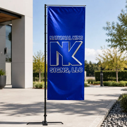 Print Solution Plus branded blue rectangular promotional flag on a black pole with cross base outside a modern building.